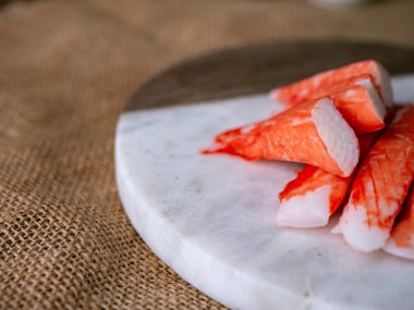 Yengeç çubuğu surimi beyaz tabakta wasibi ile.