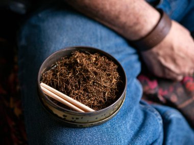 Kurutulmuş tütünle sarılmış sigara hazırlıyorum..