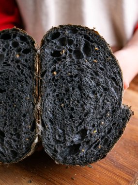 Baker Hand sunar ev yapımı taze pişmiş kömürlü ekşi ekmek. Kırıntılar içeride gösteriliyor