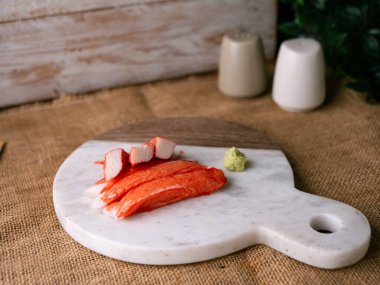Yengeç çubuğu surimi beyaz tabakta wasibi ile.
