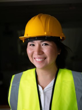 Fabrika kadın işçileri veya teknisyenleri İnşaat mühendisi veya Mimari proje yönetimi kameraya gülümsüyor.