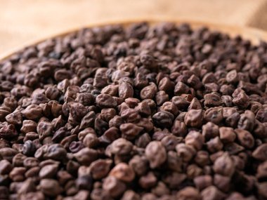 Kala Chana (Kala Chana) sade ahşap bir masa üzerinde çiğ Koyu Kahverengi Nohut. Kuru Balck nohutu (ceci neri) arkaplanı kapat.