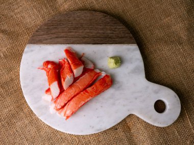Yengeç çubuğu surimi beyaz tabakta wasibi ile.