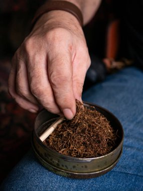 Kurutulmuş tütünle sarılmış sigara hazırlıyorum..