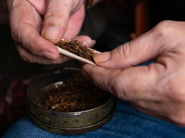 Kurutulmuş tütünle sarılmış sigara hazırlıyorum..