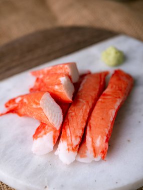 Yengeç çubuğu surimi beyaz tabakta wasibi ile.