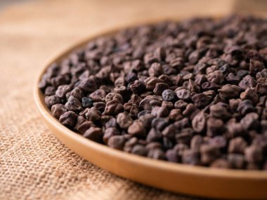 Kala Chana (Kala Chana) sade ahşap bir masa üzerinde çiğ Koyu Kahverengi Nohut. Kuru Balck nohutu (ceci neri) arkaplanı kapat.