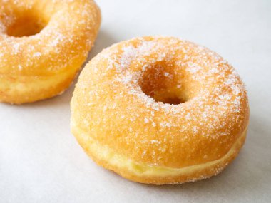 Beyaz arka planda renkli kremalı donutlar var. Boş alanı kopyala