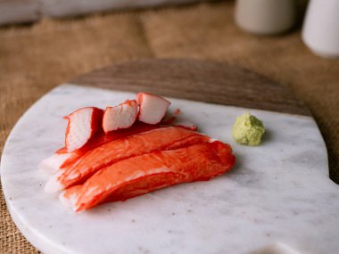 Yengeç çubuğu surimi beyaz tabakta wasibi ile.