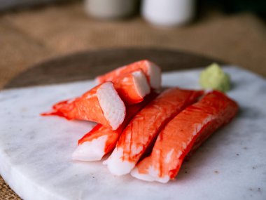 Yengeç çubuğu surimi beyaz tabakta wasibi ile.