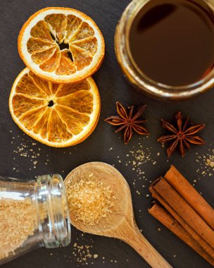 Tarçın çubukları, anason, portakal dilimleri, bal ve şeker.