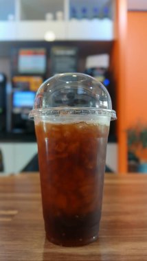 Tahta bir masada, Plastik Bardakta buzlu kahve.