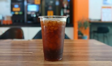 Tahta bir masada, Plastik Bardakta buzlu kahve.