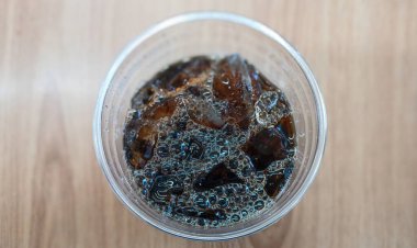 Tahta bir masada plastik bardakta buzlu kahvenin en iyi görüntüsü.