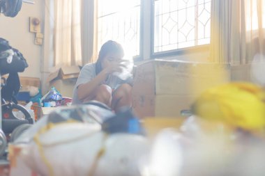 Odasını temizleyen ve gereksiz şeyleri temizleyen bir kadın. Doğal işaret fişeği de dahil.