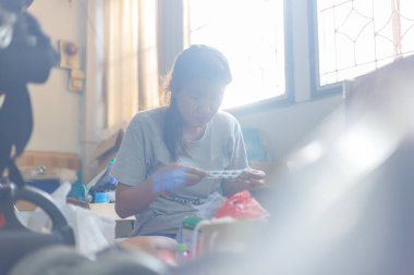 Odasını temizleyen ve gereksiz şeyleri temizleyen bir kadın. Doğal işaret fişeği de dahil.