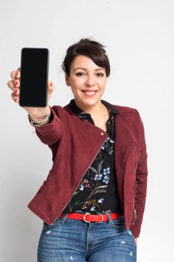 Mutlu Latin genç kadın cep telefonu ekranını gösteriyor.