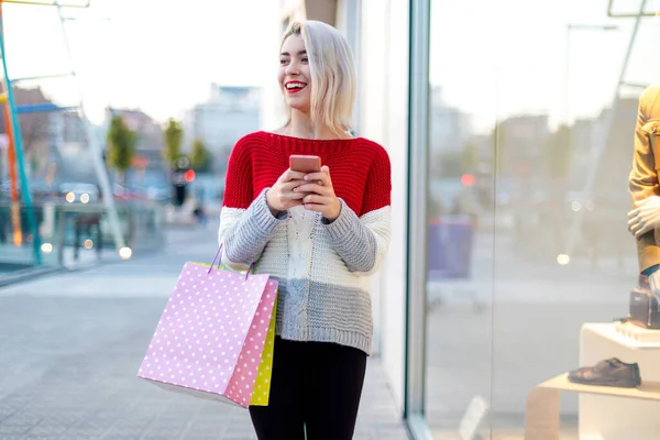 ショッピング バッグや携帯電話を持つ女性 — ストック写真