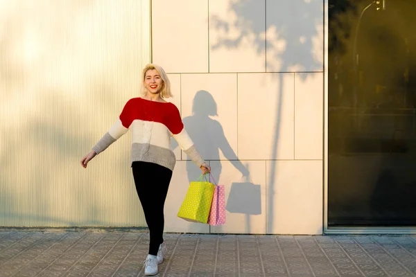 站在购物中心旁边拿着购物袋的金发女人 — 图库照片