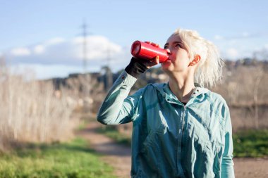 Bir şişe su içen kadın.