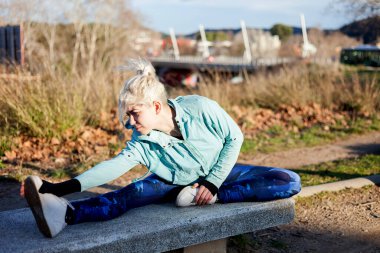 Young woman stretching during a jog on waterfront