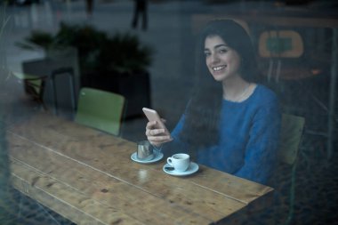 Genç kadın kullanım cep telefonu iş tatilinde, mutlu erkek moda haberleri cep telefonu restoranda kahvaltı sırasında okuma büyüleyici rahat kafede otururken portresi