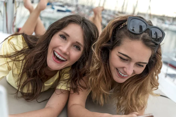 Dos Hermosas Mujeres Sonrientes Bikini Usando Una Tableta Cubierta Velero Fotos De Stock