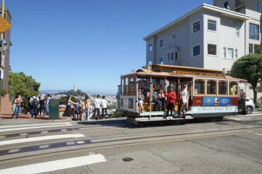 Bir teleferik Hyde caddesinde ilerliyor tarihi Lombard caddesinin önünde ve turistler orada toplandı..