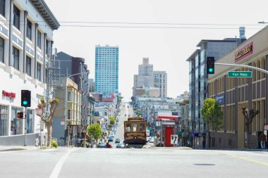 İkonik bir teleferik günün ortasında San Francisco caddesinde ilerliyor..