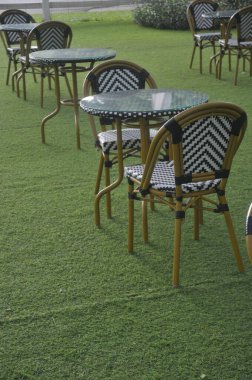 Sandalye ve masa bahçede suni çimlerin üzerine kurulmuş.
