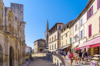 ARLES, FRANCE - 6 AĞUSTOS 2022: Solunda amfitiyatro bulunan tarihi şehir merkezi