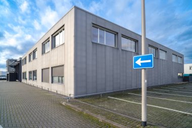 one way traffic sign along an industrial building