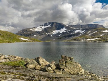 Norveç 'te tipik fiyort manzarası. Yüksek karla kaplı dağlar ve derin göller.