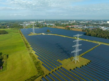 Büyük bir güneş parkının ortasında elektrik direkleri