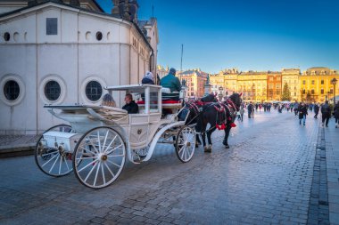 KRAKOW, POLAND - 27 ARALIK 2023: Ana Meydan tarihi konaklar (kamienice) ve kiliselerle çevrilidir. Meydanın merkezine Kumaş Salonu hakim..