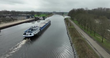 ALMELO, NETHERLANDS - 17 Şubat 2024: Ülkenin doğu kesimindeki Twente Kanalı 'ndan geçen küçük kargo gemisi