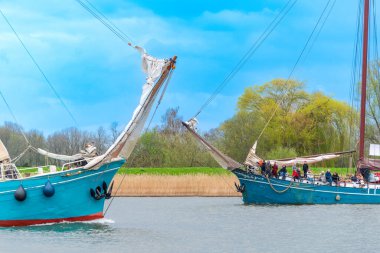 KAMPEN, NETHERLANDS - 30 Mart 2024: Yelkenli Kampen sırasında IJssel nehrinde yelkenli gezisi, Paskalya haftasonu boyunca büyük bir etkinlik.