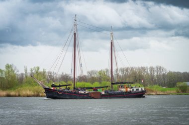 KAMPEN, NETHERLANDS - 30 Mart 2024: Yelkenli Kampen sırasında IJssel nehrinde yelkenli gezisi, Paskalya haftasonu boyunca büyük bir etkinlik.