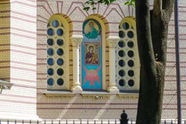 windows of the nativity cathedral in Riga, Latvia. On the right site the Latvian flag. clipart