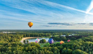 OLDENZAAL, NETHERLANDS - AUGUST 21, 2024: Lots of hot air balloons taking off at the annual Twente Ballooning festival. clipart