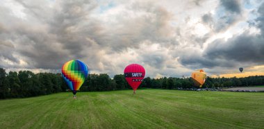DE LUTTE, NETHERLANDS - 23 Ağustos 2024: Geleneksel Twente Balon Festivali sırasında üç sıcak hava balonunun havadan görünüşü