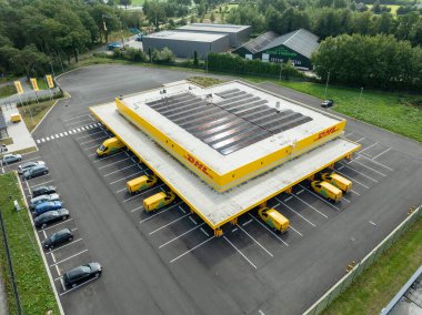 ALMELO, NETHERLANDS - AUGUST 31, 2024: Aerial view of a DHL service point with some solar panels on the roof clipart