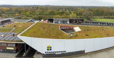 OLDENZAAL, NETHERLANDS - 10 Kasım 2024: Belediye binasının havadan görünüşü çimen, bitki ve güneş panelleriyle kaplı çatı.