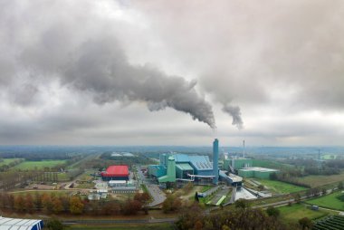 heavily smoking waste treatment plant in the Netherlands clipart