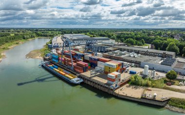 DOESBURG, NETHERLANDS - 24 AĞUSTOS 2025: IJssel nehri boyunca küçük bir terminal olan Doesburg Konteyner Terminalinin havadan görünüşü.