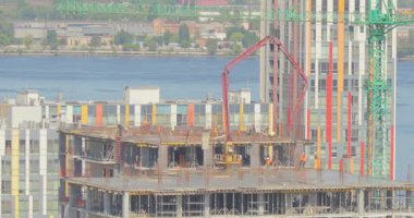 Çok katlı bir binanın şantiyesinde çalışıyorum. İşçiler zaman aşımına uğramış bir ev inşa ediyorlar. Çok katlı bir binanın zaman atlaması inşaatı. İnşaatçılar çok katlı bir zaman atlaması inşa ediyorlar.