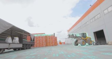 Malları kamyona yüklüyorlar. Buldozer eşyaları bir kamyonun arkasında poşetlere koyar..