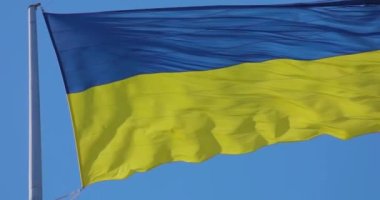 Ukrayna bayrağı rüzgarda yavaş çekimde dalgalanıyor. Bayrak direğindeki Ukrayna bayrağı yavaş çekimde..