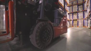 Forklift kullanan bir işçi bir depoda çalışacaktır. Büyük, modern bir depo. Depo çalışması.