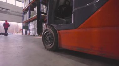 Depodan geçen bir forkliftin yakın çekimi. Forklift hareket halinde, yakın plan. Forklift tekerlekleri yakın çekim.
